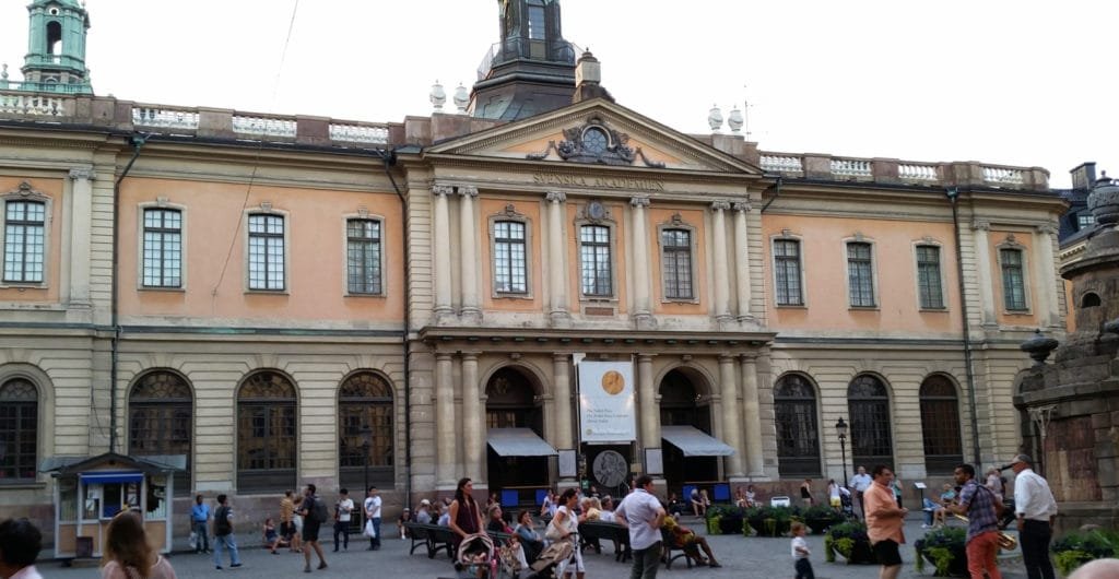 Solrik dag i Stockholms skjærgård med folk ved Vaxholms festning og lystbåter i bakgrunnen.