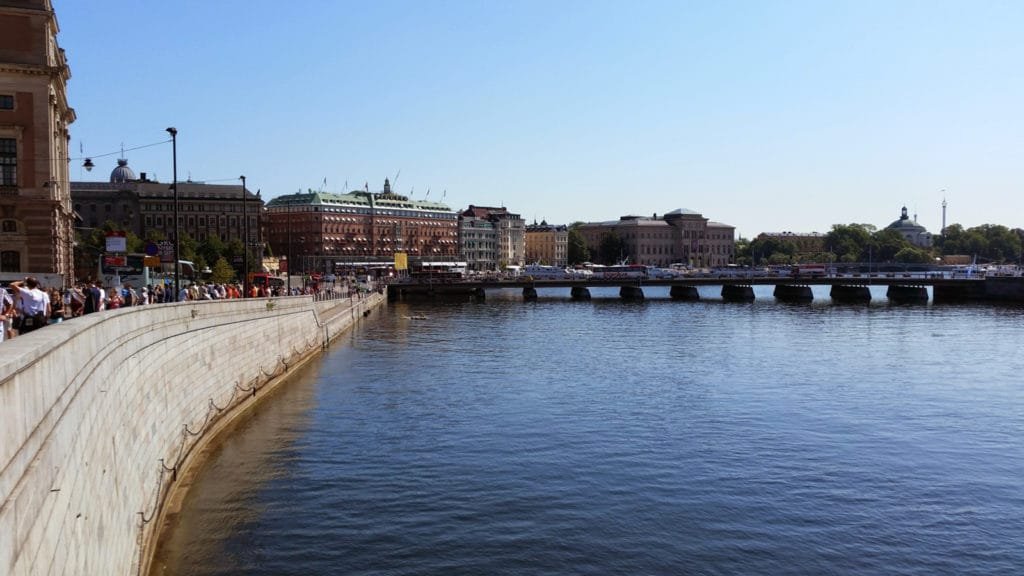 Utsikt over Stockholms skjærgård med broen og historiske bygninger under en klar blå himmel.
